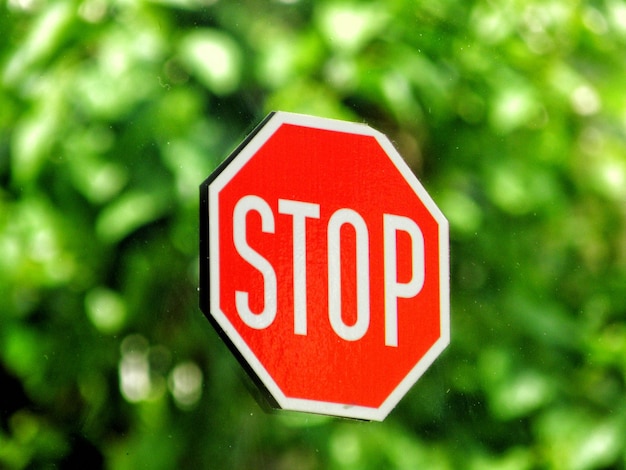 Close-up di un segnale di stop su vetro con riflesso