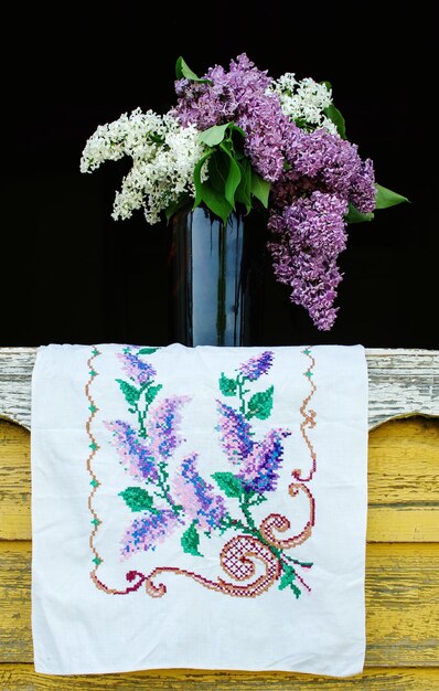 Close-up di un vaso di fiori viola su un tovagliolo ricamato