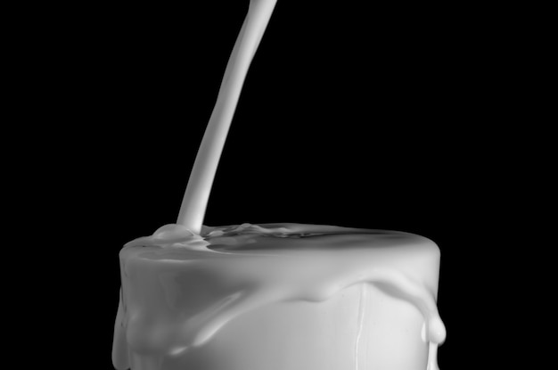 Close-up di un versamento di latte su uno sfondo nero