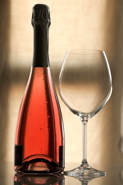 Close-up di una bottiglia di vino rosso e di un bicchiere sul tavolo