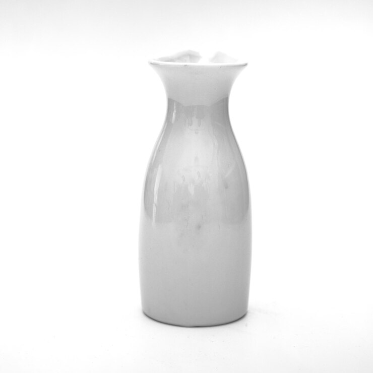Foto close-up di una brocca di ceramica su sfondo bianco