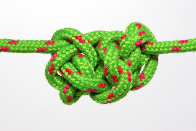 Close-up di una corda verde incastrata su uno sfondo bianco