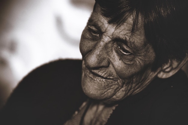 Close-up di una donna anziana che guarda lontano mentre è in piedi all'aperto