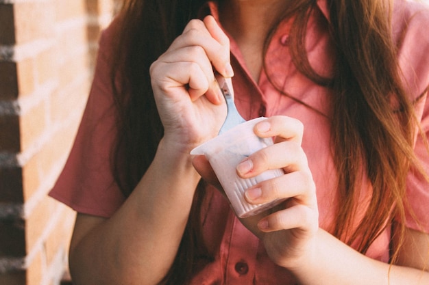 Close-up di una donna che mangia yogurt