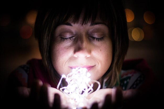 Close-up di una donna che tiene le luci delle fate