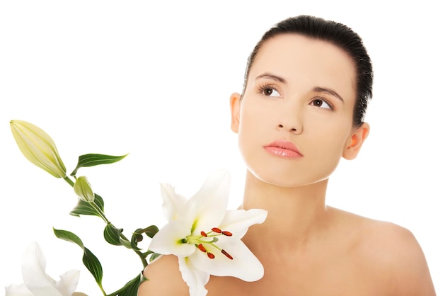 Close-up di una donna pensierosa con dei fiori su uno sfondo bianco