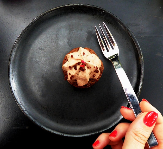 Close-up di una donna tagliata che mangia il dessert a casa