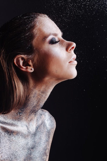 Close-up di una giovane donna che guarda su uno sfondo nero