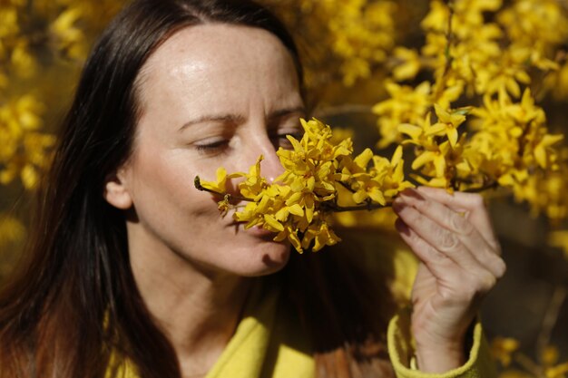 Close-up di una giovane donna con un fiore giallo