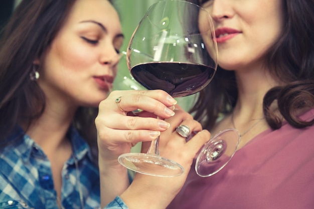 Close-up di una giovane donna sorridente che beve un bicchiere
