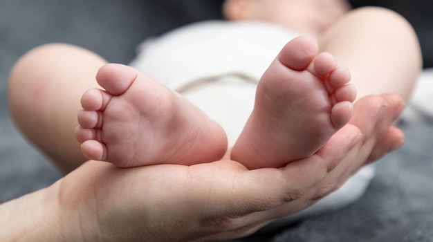 Close-up di una madre tagliata che tiene i piedi del bambino