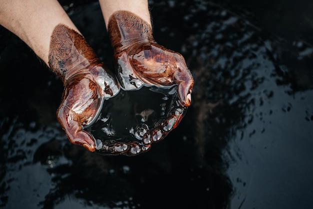 Close-up di una mano che tiene il petrolio greggio