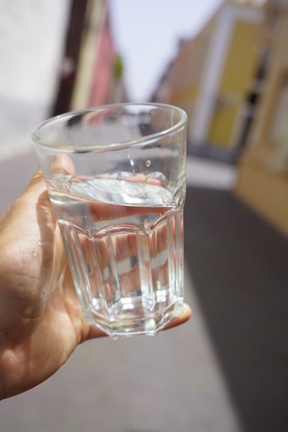Close-up di una mano che tiene un bicchiere d'acqua