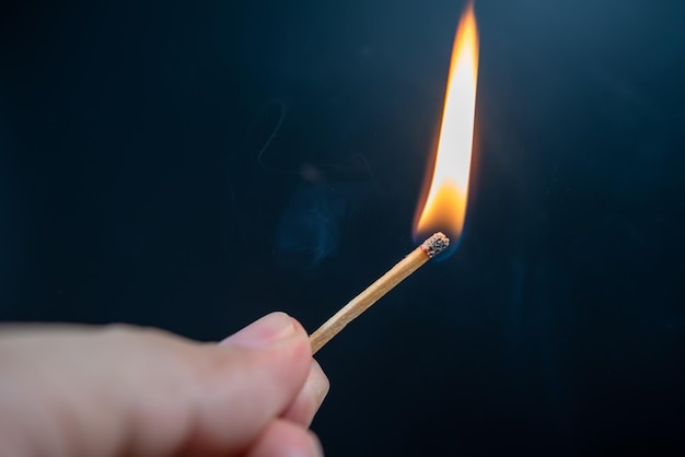 Close-up di una mano che tiene una candela accesa