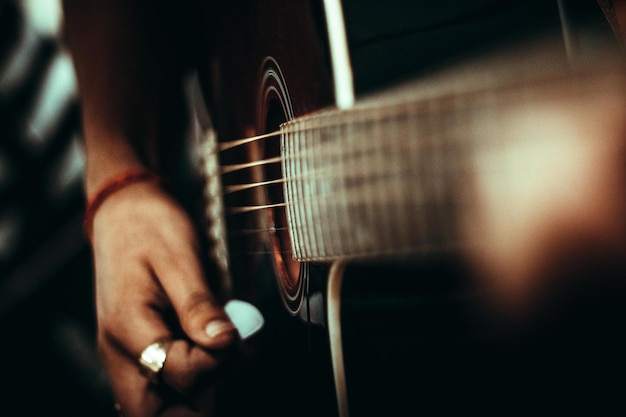 Close-up di una mano tagliata che suona la chitarra