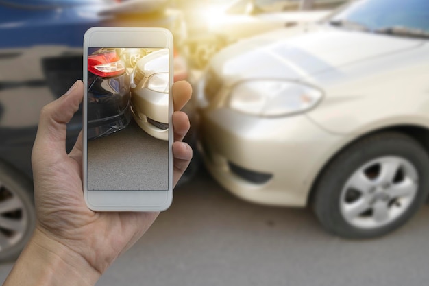 Close-up di una persona che fotografa un'auto mentre usa uno smartphone