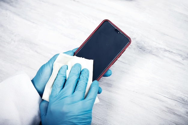 Close-up di una persona che tiene un telefono cellulare sul tavolo
