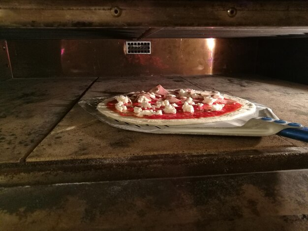 Close-up di una pizza sulla padella nel forno