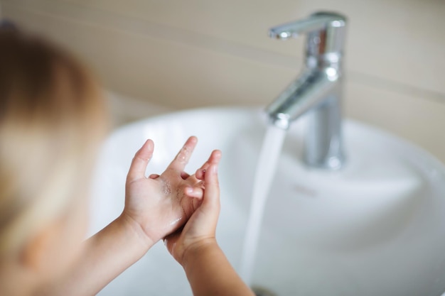 Close-up di una ragazza che si lava le mani vicino al lavandino del bagno