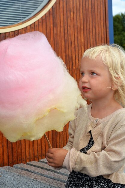 Close-up di una ragazza che tiene il cotone dolce