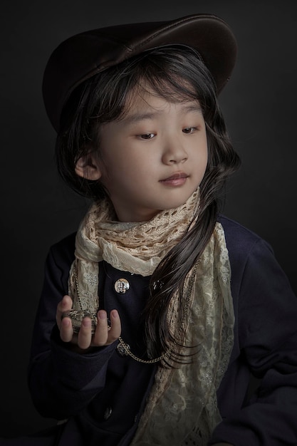 Close-up di una ragazza con una collana su uno sfondo nero