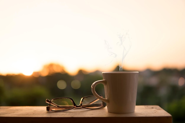 Close-up di una tazza di caffè sul tavolo contro il cielo durante il tramonto