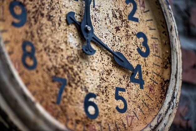 Close-up di vecchio orologio situato sul muro di mattoni