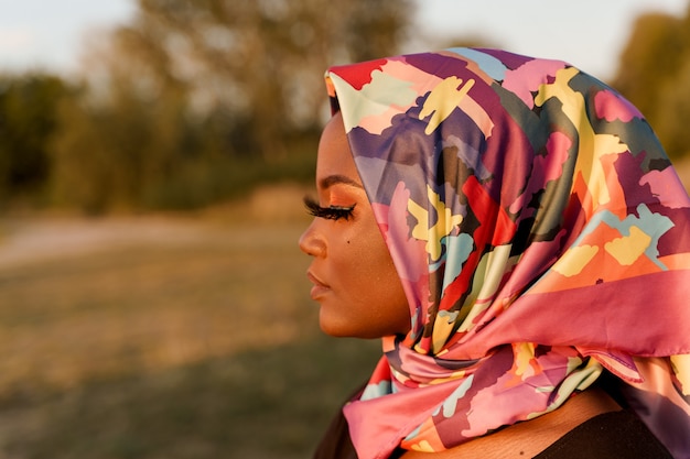 Close up donna nera africana indossata in sciarpa denominata hijab guardando a sinistra