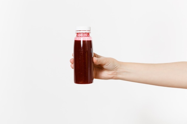 Close up femmina tiene in mano rosso scuro detox frullati in bottiglia isolati su sfondo bianco. Una corretta alimentazione, bevanda vegetariana stile di vita sano, concetto di dieta. Area pubblicitaria per copia spazio.