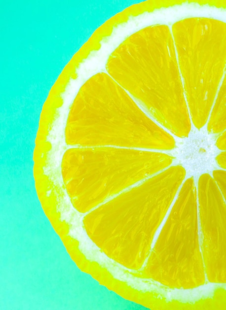 Close up foto di texture di limone su sfondo blu. Frutta tagliata a metà, all'interno, vista macro. Carta da parati verticale per smartphone. Minimalismo, originale e creativo.