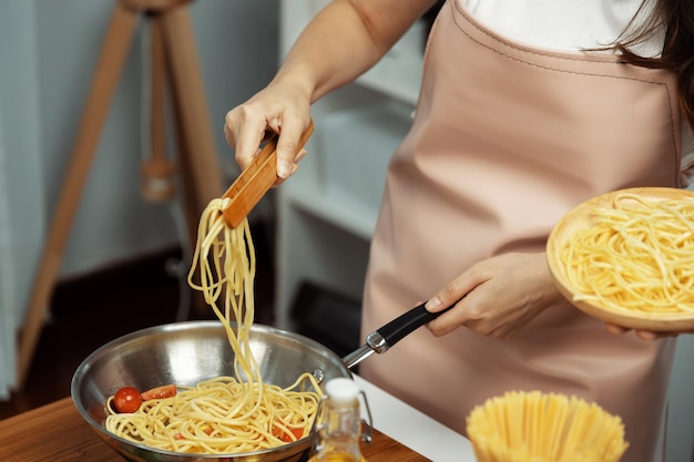 Close up influencer cucina spaghetti mix ingrediente a padella postulato