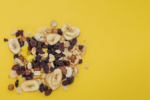 Close-up mix di noci e frutta secca su uno sfondo giallo, copia dello spazio. Il concetto di dieta, una corretta alimentazione.