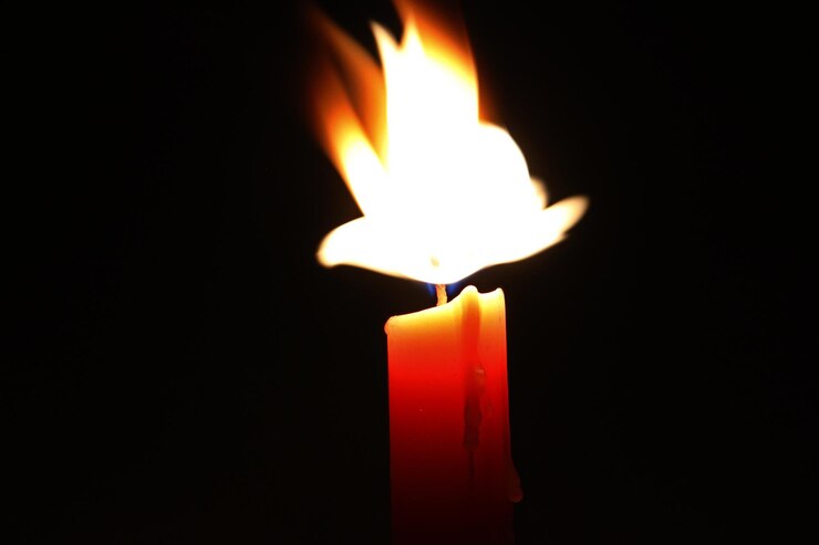 Photo close-up of burning candle in darkroom