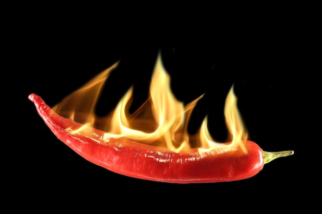 Close-up of burning red chili pepper against black background