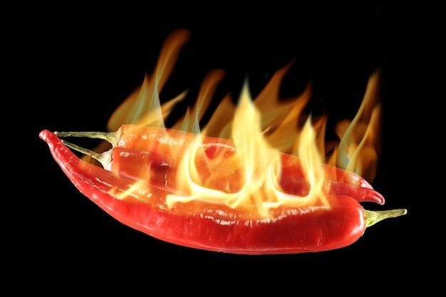 Close-up of burning red chili peppers against black background