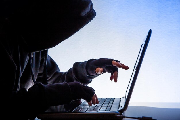 Close-up of hacker using laptop