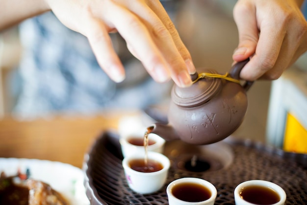 Close-up of human hands with teapot