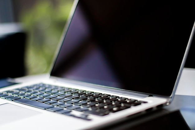 Close up of modern laptop on table in sunny interior Business and technology concept