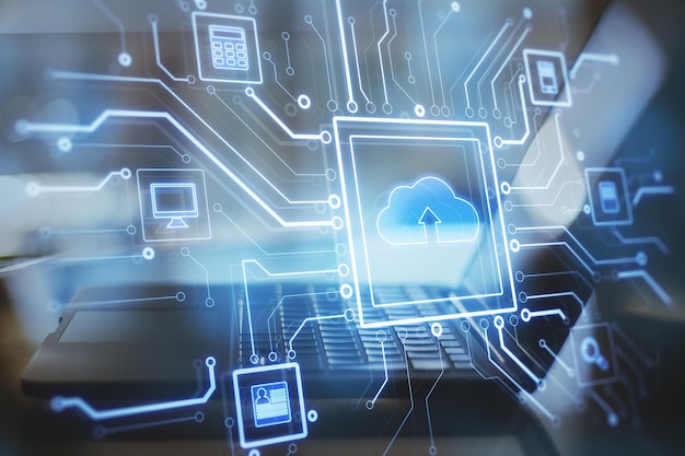 Close up of notebook computer at desktop with abstract glowing circuit cloud computing interface on blurry blue bokeh background Information technology and network concept