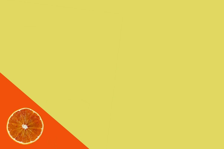 Photo close-up of orange fruit against yellow background