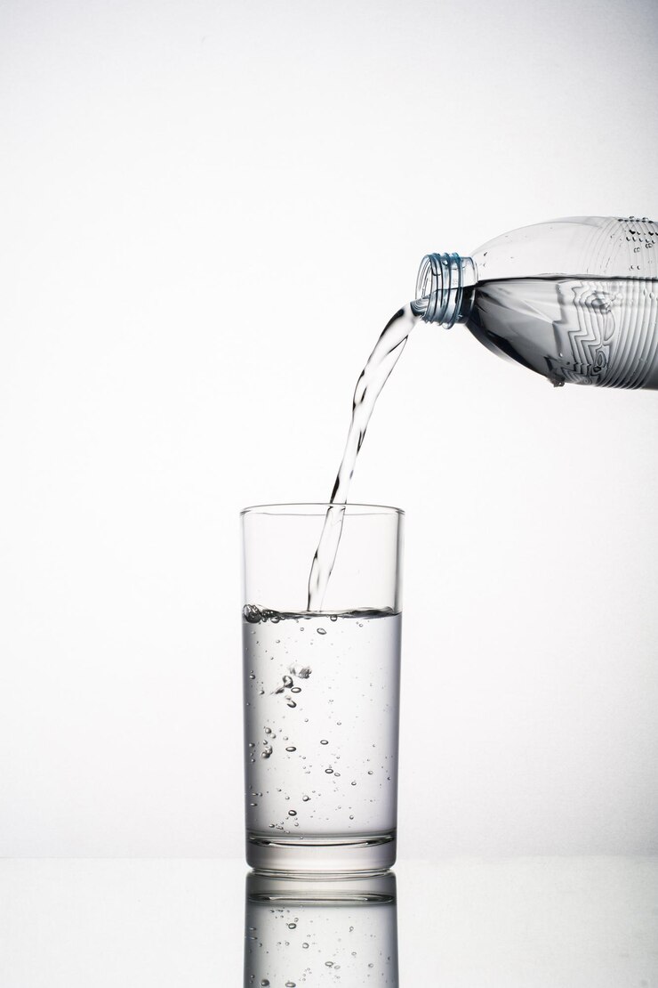 Close up of pouring water splashing from glass isolated on white background