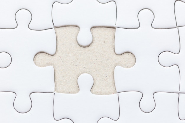 Close up of White jigsaw puzzle con pezzo mancante