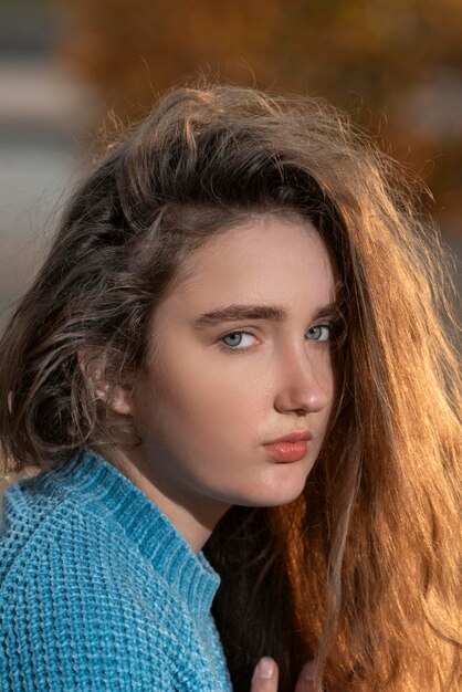 Close up ritratto di giovane ragazza con capelli castani e occhi azzurri guardando nella fotocamera Cornice verticale