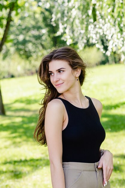 Close up ritratto di una bella ragazza sorridente con i capelli castani all'aperto.