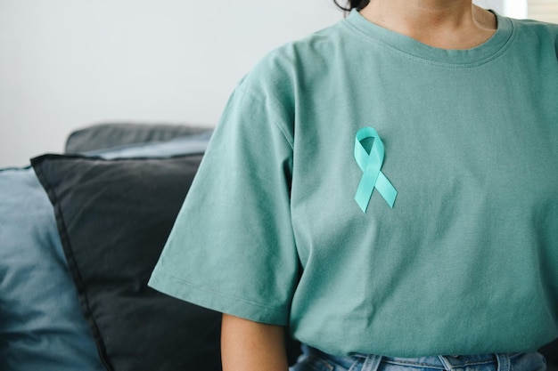 Close up Teal Awareness Ribbon su Teal T-Shirt per sostenere la sopravvissuta al cancro cervicale