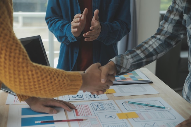 Close up ux developer e ui designer brainstorming sull'interfaccia dell'app mobile wireframe design sul tavolo con breif del cliente e codice colore in un ufficio modernoagenzia di sviluppo digitale creativa