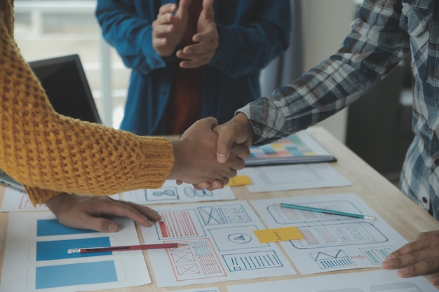 Close up ux developer e ui designer brainstorming sull'interfaccia dell'app mobile wireframe design sul tavolo con breif del cliente e codice colore in un ufficio modernoagenzia di sviluppo digitale creativa