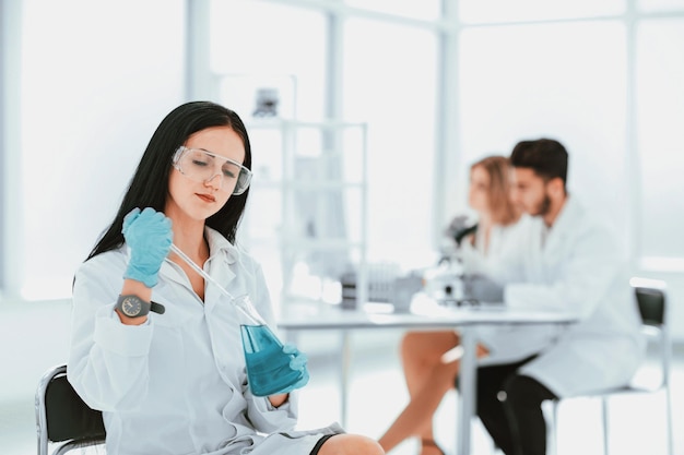 Close up.woman scienziato prende un campione del liquido. foto con copia spazio