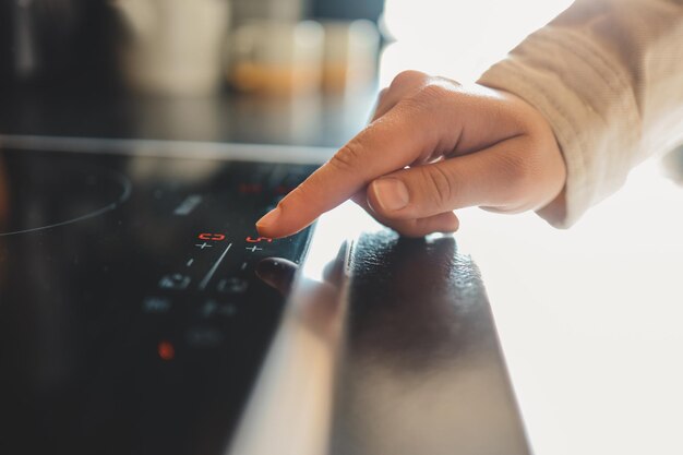 Closeup di accendere la stufa elettrica Azione Accendere il pannello della piastra elettronica Pannello con pulsanti a sfioramento sulla piastra elettronica