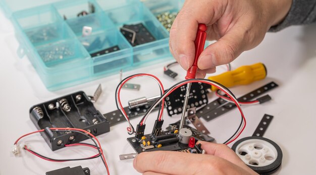Closeup di mani che assemblano giocattoli educativi di robotica concetto di istruzione STEM